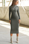 Full body front view of model posing in the fitted mineral rib Mock Neck Midi Dress with a mock turtleneck neckline, long sleeves and a mid-calf length