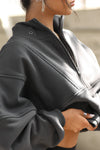 Close up side view of model posing in the oversized comfortable charcoal luxe french terry Retro Half Zip pullover sweatshirt with ribbed accents on the chest and sleeves, a hidden kangaroo pocket and a half zip collar