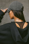 Back view of model posing in the six-panel washed black Official Cap with a curved brim and adjustable strap