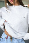 Close up front view of model posing in the soft oversized pearl grey french terry Classic Crew Pullover sweatshirt with a crew neckline and joah brown logo patch sewn on the upper left chest