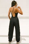 Back view of model posing in the full length black modal Open T-Back Cami