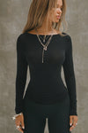 Front view of model posing in the fitted, light weight black modal Boatneck Long Sleeve with a boat neckline