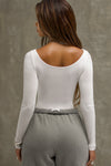 Back view of model posing in the fitted, light weight white modal Boatneck Long Sleeve with a boat neckline