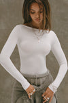 Front view of model posing in the fitted, light weight white modal Boatneck Long Sleeve with a boat neckline