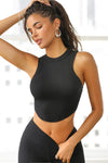 Front view of model posing in the fitted body tank in black rib with a thick binding at the neckline and arms and a raw cut hem