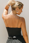 Back view of model posing in the fitted stretchy black Cinched Cami tank with a sweetheart neckline, gathered detail at the bust and delicate corded straps