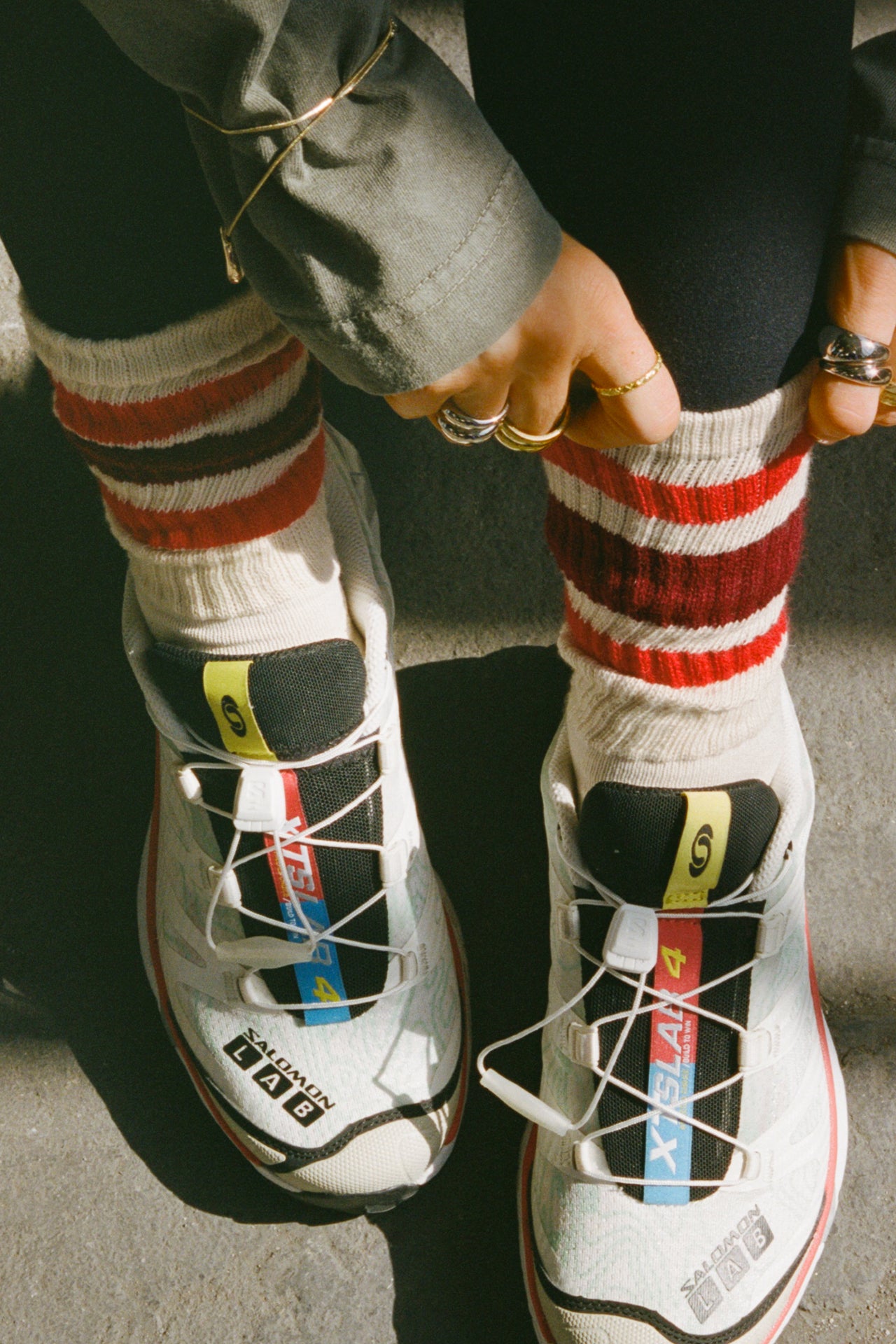 Front view of model adjusting the crew style ribbed soft red burgundy Classic Stripe Sock