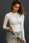 Front view of model posing in the fitted and stretchy bone rib Crewneck Long Sleeve with a banded crew neckline