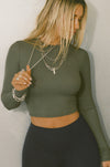 Front view of model posing in the fitted cropped mineral rib Cropped Crew Long Sleeve top with a crew neckline