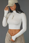 Front view of model posing in the fitted soft chalk modal Cropped Mock Neck Long Sleeve top with a raw cut hem