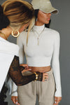 Front view of model posing in the fitted soft chalk modal Cropped Mock Neck Long Sleeve top with a raw cut hem