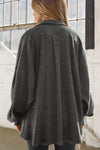 Back view of model posing in the oversized ink luxe knit Deep V Pullover with a plunging collared neckline, dropped shoulders and back panel details