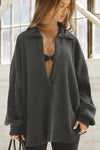 Front view of model posing in the oversized ink luxe knit Deep V Pullover with a plunging collared neckline and dropped shoulders