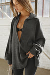 Front view of model posing in the oversized ink luxe knit Deep V Pullover with a plunging collared neckline and dropped shoulders