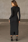 Full body back view of model posing in the fitted black flexrib Clasp Midi Dress with long sleeves, a crew neckline and front cutouts cinched together with metal clasp embellishments