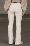 Back view of model from the waist down posing in the mid-rise fitted natural luxe knit Fitted Mini Flare Pant with a slightly flared leg