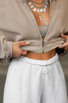 Close up detail front view of model posing in the oversized loose fit pearl grey french terry Oversized Jogger with an elastic waistband and ankle cuffs