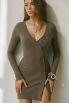 Front view of model posing in the soft and fitted army luxe knit Asymmetrical Button Mini Dress with long sleeves,  a v-neckline and asymmetrical button-front details. 