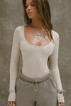 Front view of model posing in the fitted and stretchy dune rib Classic Scoop Long Sleeve with a scoop neckline