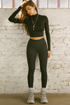 Full body front view of model posing the full length and high-waisted sueded onyx Second Skin Legging with a wide, v-shaped waistband