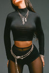 Close up front view of model posing in the fitted soft black modal Cropped Mock Neck Long Sleeve top with a raw cut hem