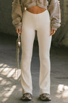 Front view of model from the waist down posing in the mid-rise fitted natural luxe knit Fitted Mini Flare Pant with a slightly flared leg