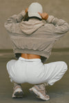 Back view of model squatting and posing in the oversized loose fit pearl grey french terry Oversized Jogger with an elastic waistband and ankle cuffs