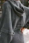 Close up back view of model posing in the loose-fit cropped washed black french terry Deconstructed Crop Zip Hoodie with exposed seams and back panel details