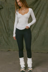 Full body front view of model posing in the fitted pearl grey rib Henley Long Sleeve with a notch in the scoop neckline