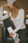 Front view of model posing in the fitted pearl grey rib Henley Long Sleeve with a notch in the scoop neckline