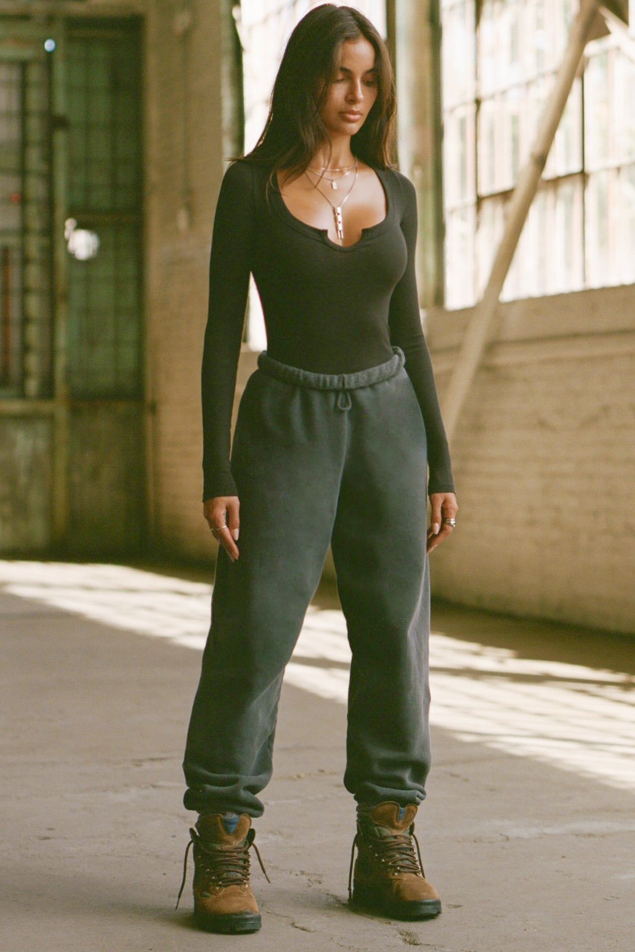 Full body front view of model posing in the fitted vintage black Henley Long Sleeve with a notch in the scoop neckline