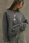 Front view of model posing in the relaxed fit washed black french terry Oversized Crew Pullover sweatshirt with dropped sleeves and a ribbed crew neckline