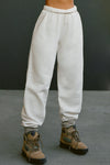 Front view of model from the waist down posing in the oversized loose fit off white french terry Oversized Jogger with an elastic waistband and ankle cuffs