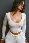 Front view of model wearing the fitted soft chalk modal Scoop Neck Long Sleeve top with a deep scoop neckline and fitted sleeves