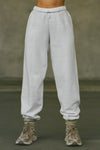 Front view of model from the waist down posing in the oversized loose fit pearl grey french terry Oversized Jogger with an elastic waistband and ankle cuffs