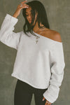 Front view of model posing in the oversized pearl grey french terry Slouchy Pullover Sweatshirt with a wide, off-the-shoulder neckline and a JOAH BROWN logo patch on the right sleeve