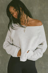 Front view of model posing in the oversized pearl grey french terry Slouchy Pullover Sweatshirt with a wide, off-the-shoulder neckline and a JOAH BROWN logo patch on the right sleeve