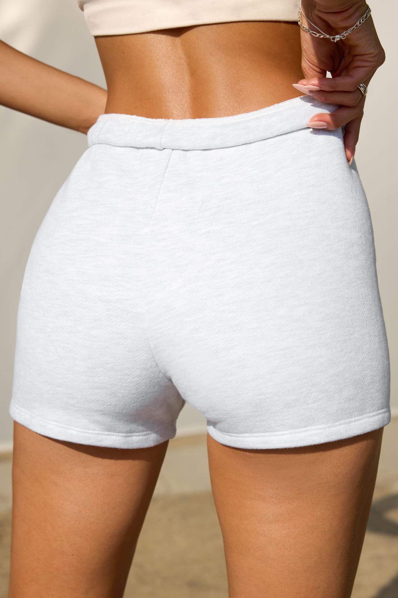 Close up back view of model from the waist down wearing the high-waisted pearl grey french terry Fitted Sweat Short with an elastic waistband