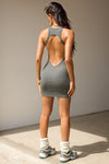 Full body back view of model posing in the mini, fitted mineral rib Open Back Dress with a low scoop neckline and open back