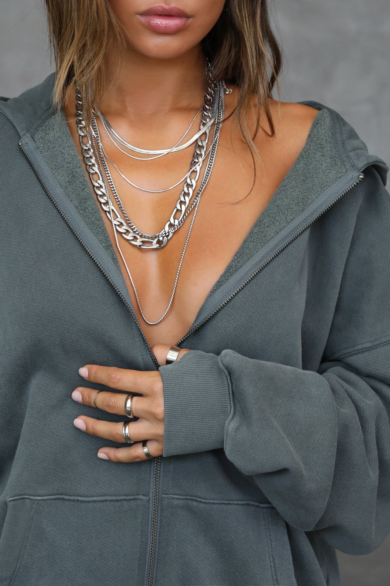 Close up front view of model posing in the oversized comfortable evergreen french terry Oversized Zip Hoodie with a full length front zip closure, side pockets and thumbholes in the fitted cuffs