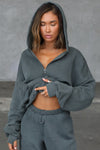 Front view of model posing in the oversized comfortable evergreen french terry Oversized Zip Hoodie with a full length front zip closure, side pockets and thumbholes in the fitted cuffs