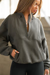 Front view of model posing in the oversized comfortable sage luxe french terry Retro Half Zip pullover sweatshirt with ribbed accents on the chest and sleeves, a hidden kangaroo pocket and a half zip collar