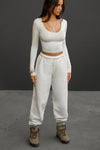 Full body front view of model posing in the oversized loose fit off white french terry Oversized Jogger with an elastic waistband and ankle cuffs