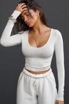 Front view of model wearing the fitted soft chalk modal Scoop Neck Long Sleeve top with a deep scoop neckline and fitted sleeves