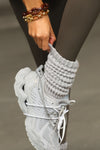 Close up side view of model adjusting the  slouchy salt Scrunch Sock with extra long ribbed cuffs