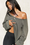 Front view of model posing in the oversized washed sage french terry Slouchy Pullover Sweatshirt with a wide, off-the-shoulder neckline and a JOAH BROWN logo patch on the right sleeve