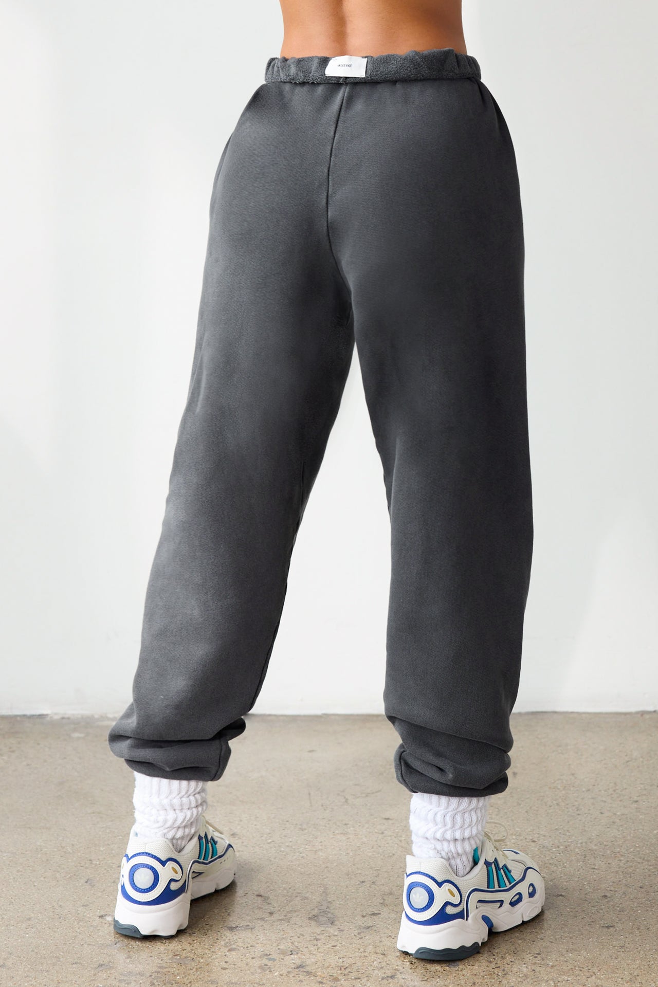 Back view of model from the waist down wearing the oversized loose fit washed black french terry Oversized Jogger with an elastic waistband and ankle cuffs