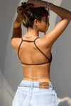 Back view of model posing in the fitted sueded umber Strappy Open Back Bra with a scoop neckline and strappy open back design