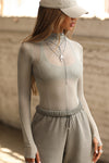 Front view of model posing in the fitted and sheer dew mesh Exposed Seams Long Sleeve top with a mock neckline and exposed seam details