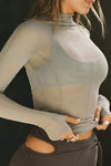 Closeup front view of model posing in the fitted and sheer dew mesh Exposed Seams Long Sleeve top with a mock neckline and exposed seam details